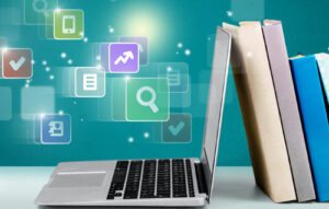 Stack of books with laptop on table